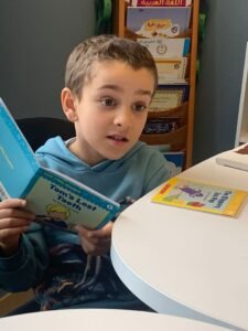 job openings islamic school teacher. ehsan islamic school. a young boy in a blue shirt excitedly reading